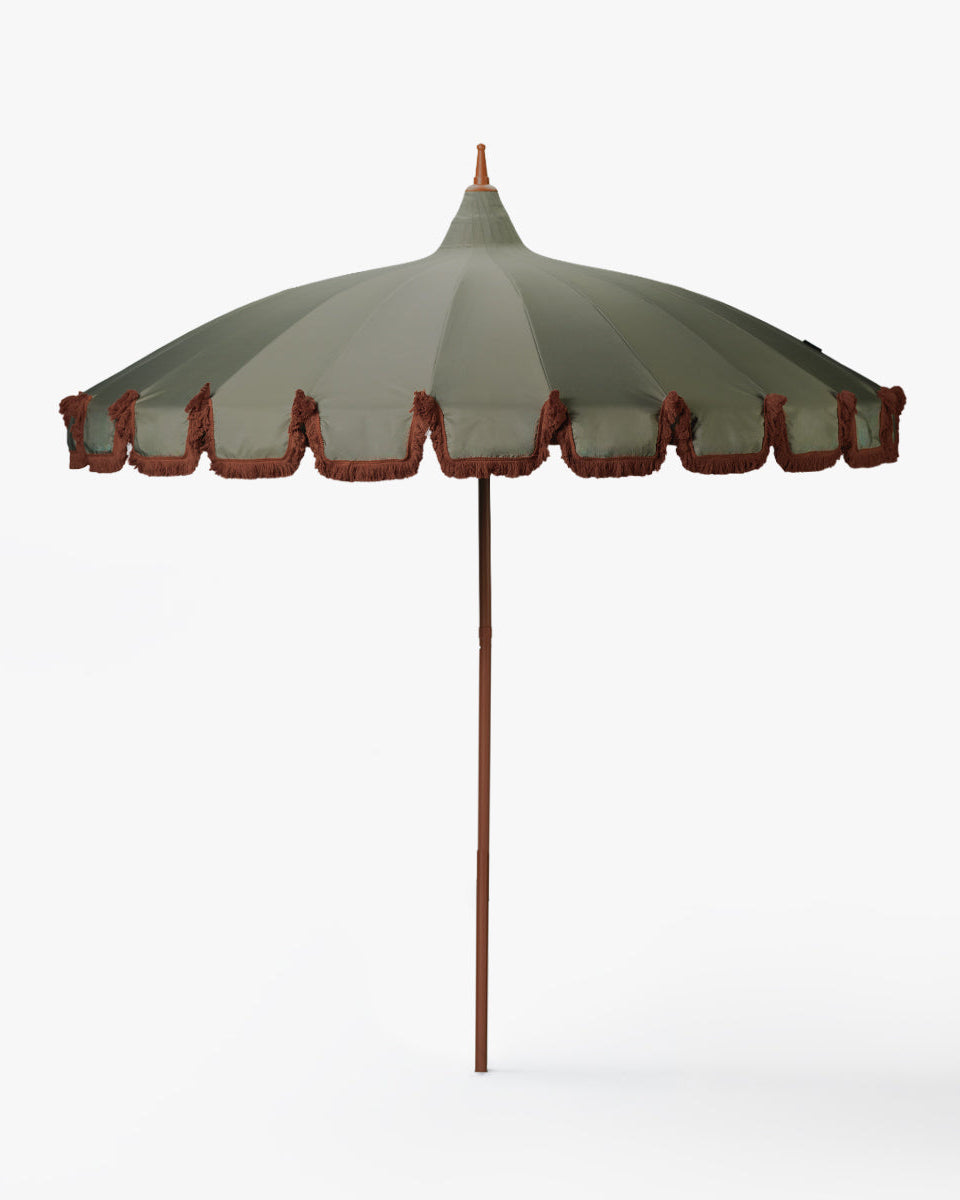 Decorative umbrella with a green canopy and red trim on a white background