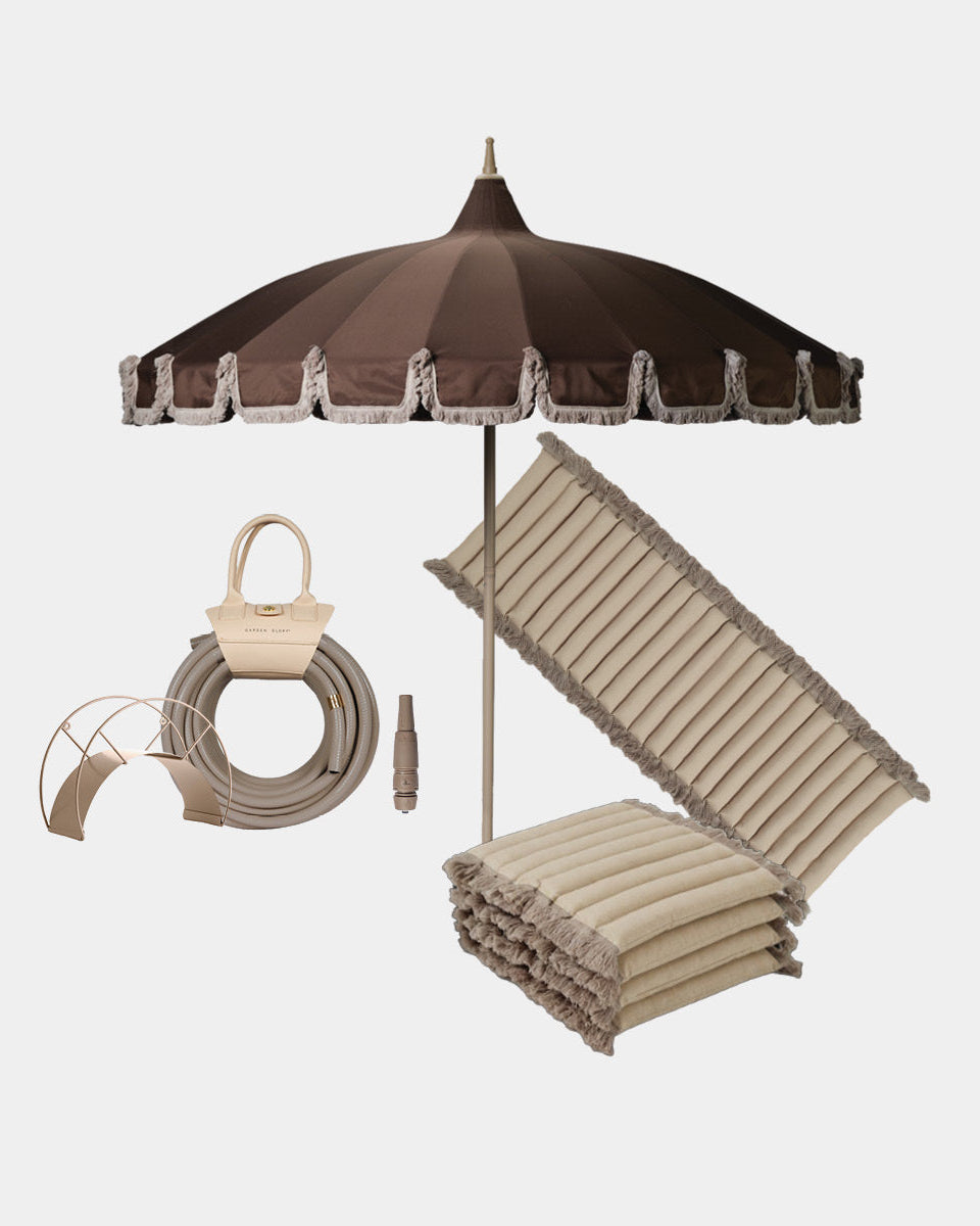 Outdoor patio umbrella set with a dark brown canopy, beige fringed trim, seat cushion in beige with fringe, a garden hose beige,  on a light gray background.