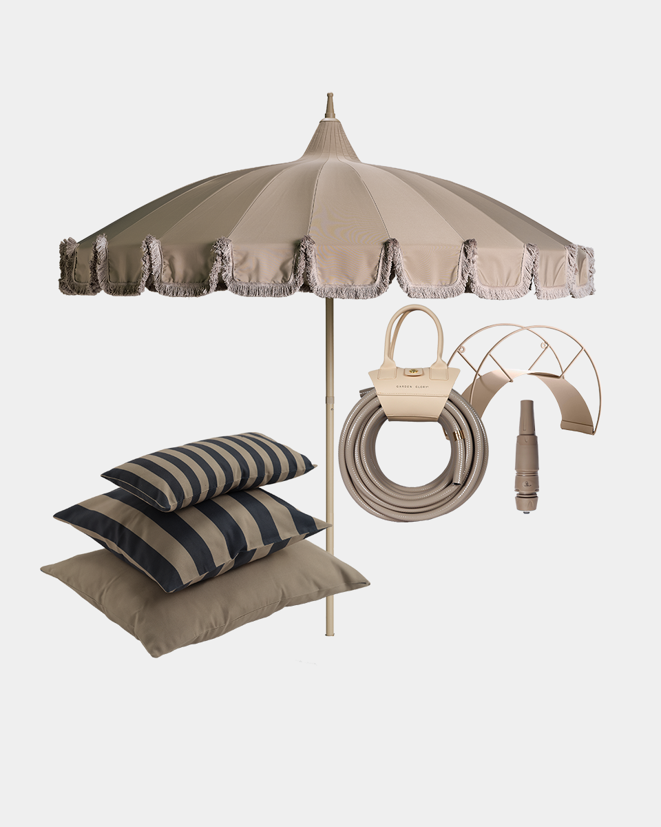 Beige patio umbrella set with fringed trim, matching hose, handbag, and striped throw pillows on a white background.