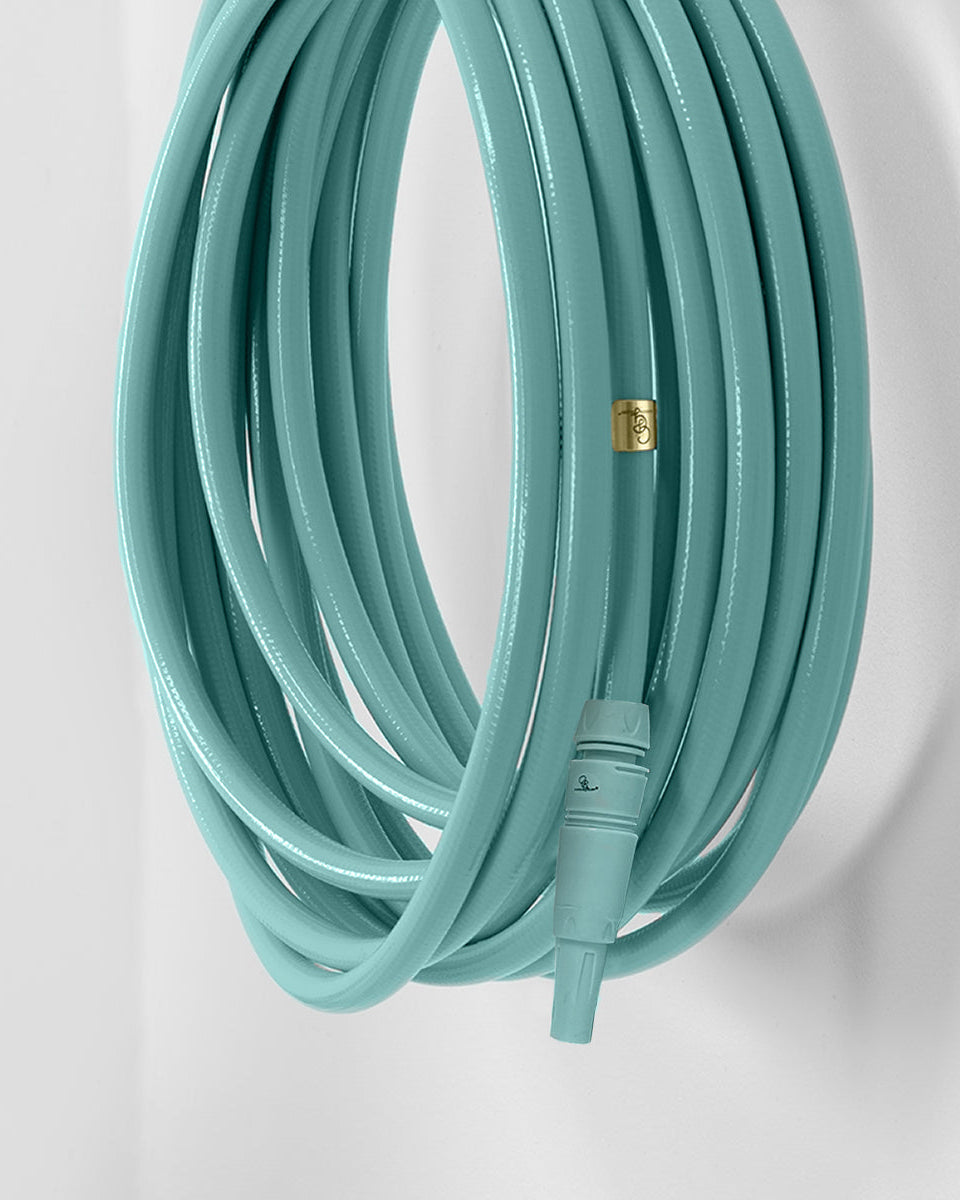 Garden hose with a gold connector on a light gray background