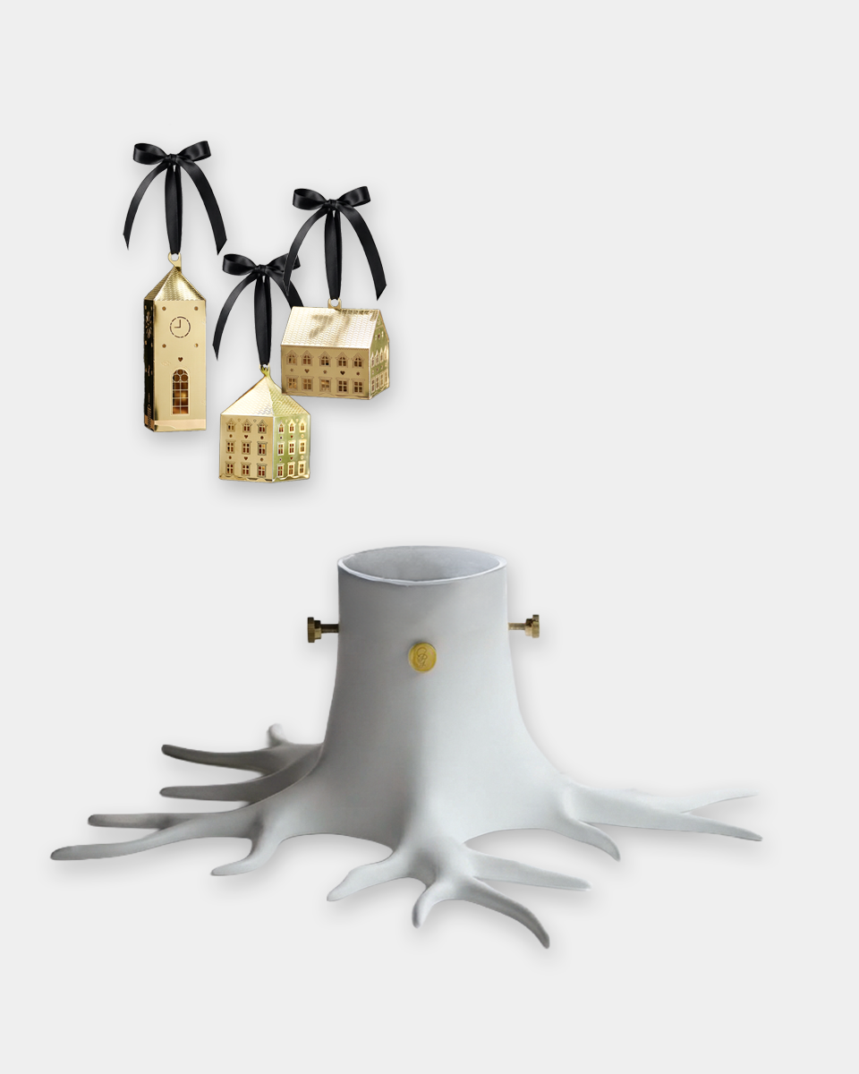 A white tree stump-shaped Christmas ornament with gold accents and three hanging gold house ornaments with black ribbons, shown on a light gray background.