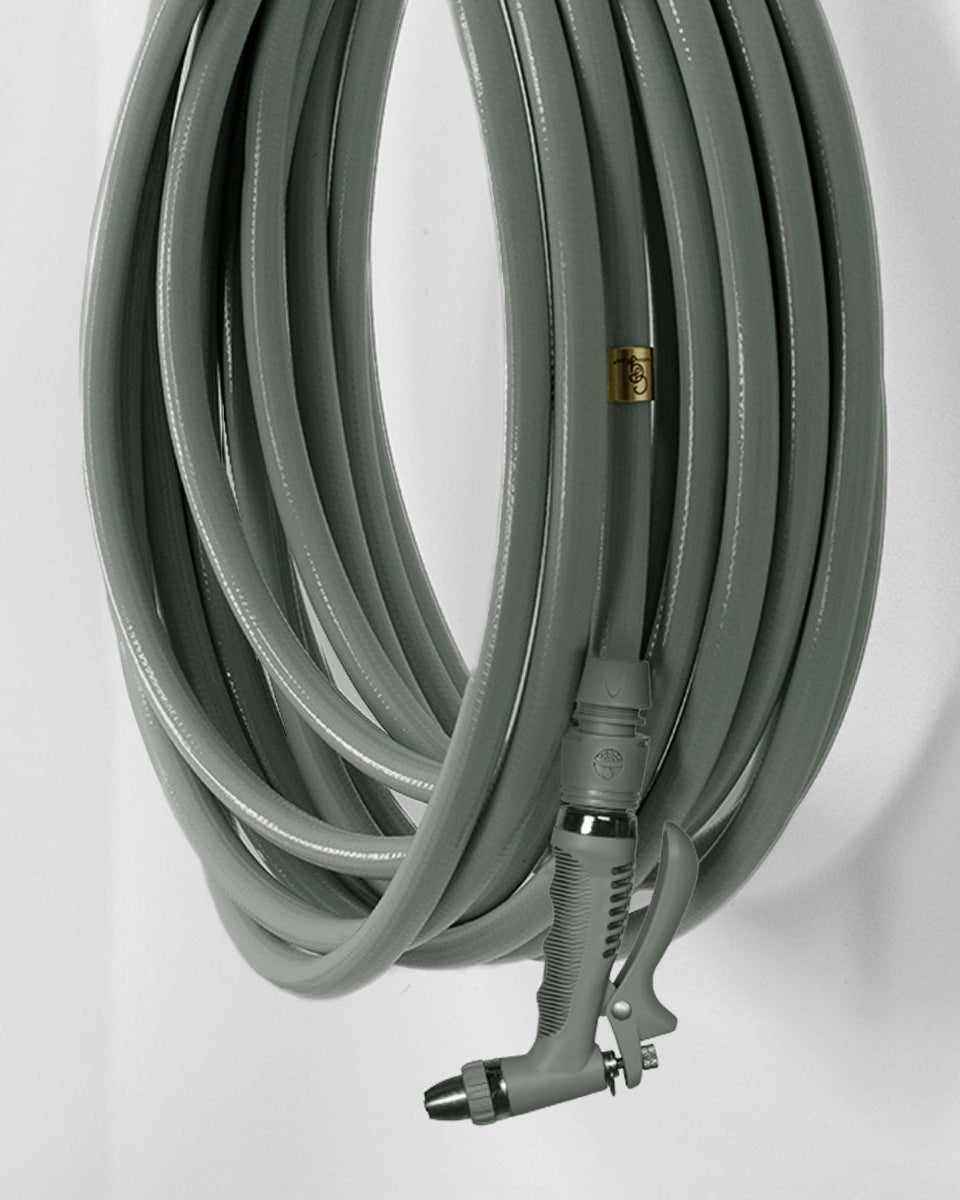 Eucalyptus green garden hose with spray nozzle on a white background