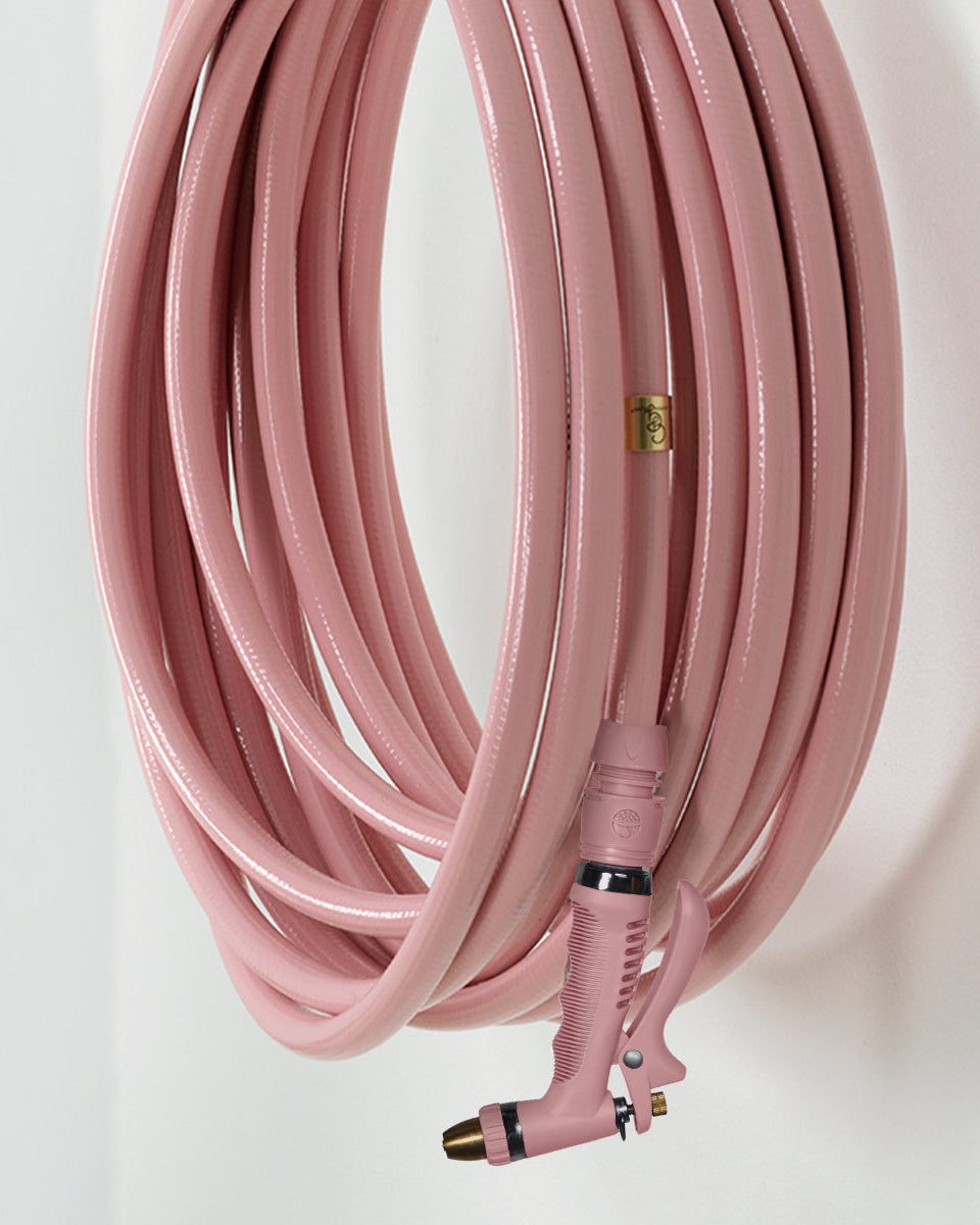 Pink garden hose with a nozzle on a white background